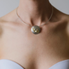 Model wearing Bloom pendant silver and 22ct gold.