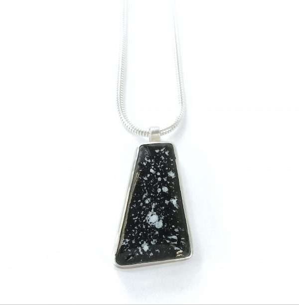 Silver pendant set with black tile on white background