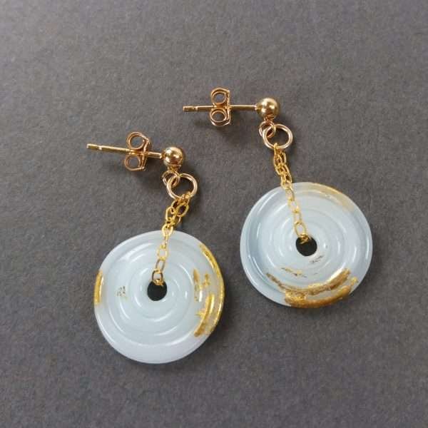 Pale blue disc earrings with gold fittings on grey background