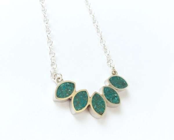 Silver leaf shaped pendant filled with ground turquoise set in resin, on silver chain.