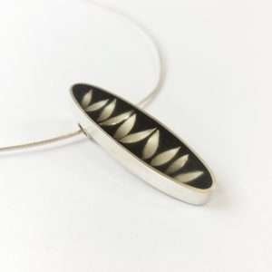 Oval silver and resin pendant with leaf shapes on torque