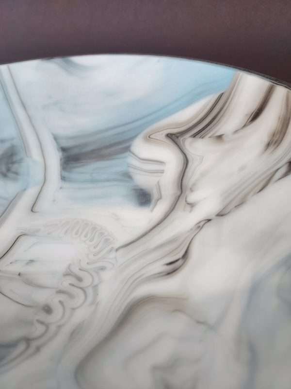 Detail of patter on glass plate white, blue black, grey swirls