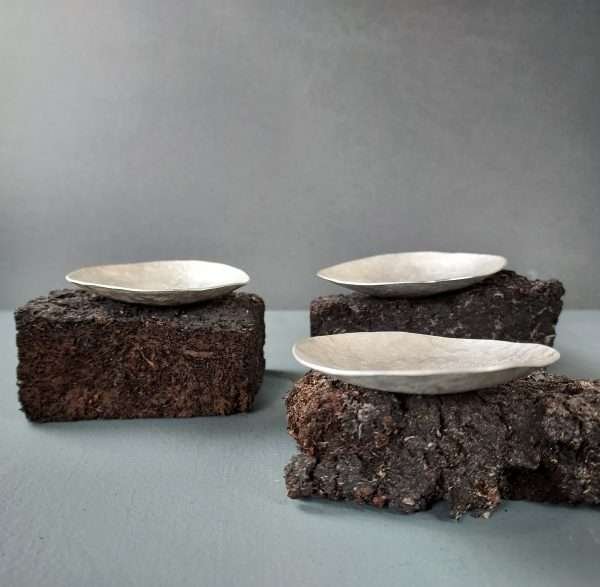 Group of three silver bowls on peat bases