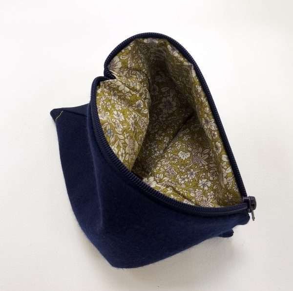 Inside green pattern fabric of navy fabric pouch with zip closure
