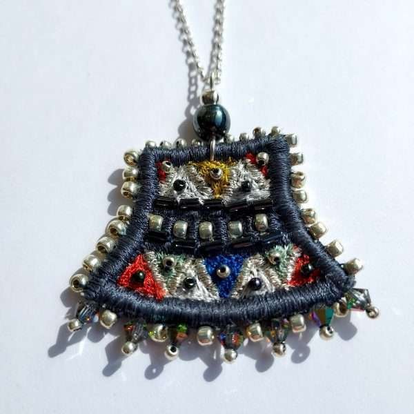 Embroidered slate coloured pendant on silver chain