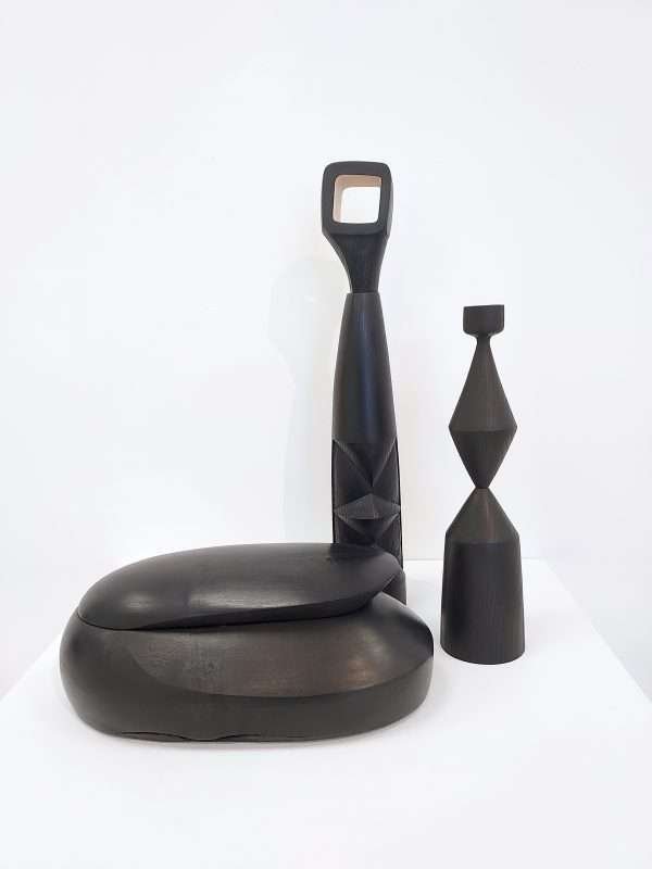 Collection of ebonised ash sculpture, candle stick and box