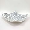 an irregularly shaped porcelain platted with an inlaid pattern of dark blue lines