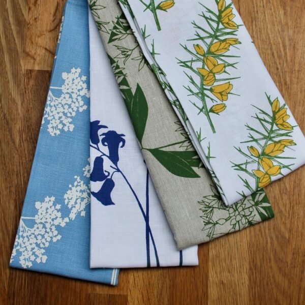 4 folded linen tea towels in various wildflower patterns and colours